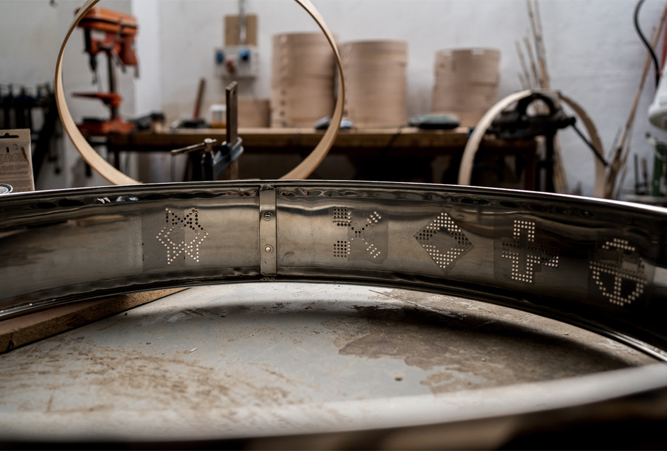 Caja (parte de un tambor) metálica con decoraciones en taller de artesanía del tambor.
